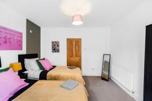 1 dormitorio con 2 camas y espejo en Classy Abode in Hackney - Garden - Sleeps 6 en Londres