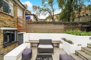 un patio con banco y silla en Classy Abode in Hackney - Garden - Sleeps 6 en Londres