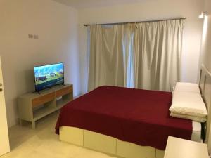 a bedroom with a bed and a flat screen tv at Condo Costa Azul in Costa Azul