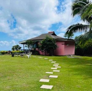 a path in the grass in front of a house at MOOREA Bungalow Kohimana avec vue lagon in Moorea