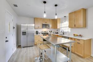 a kitchen with wooden cabinets and a stainless steel refrigerator at Chic Tallahassee Vacation Rental Near Universities in Tallahassee