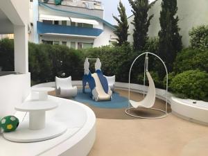 un patio con muebles blancos y azules frente a un edificio en Hotel Al Cavallino Bianco, en Riccione