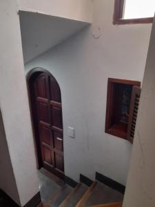a stairway with a wooden door and a window at Casabunda Multiespacio - Habitación privada in Salta
