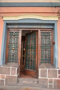 una entrada a un edificio con puertas de hierro verdes en Casabunda Multiespacio - Habitación privada en Salta