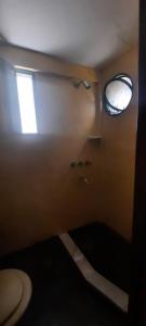 baño pequeño con aseo y ventana en Casabunda Multiespacio - Habitación privada en Salta