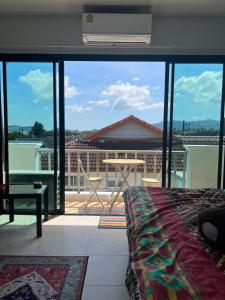 1 dormitorio con vistas a un balcón en Petunya Phuket en Ban Huai Luk (1)