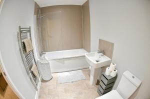 a white bathroom with a sink and a toilet at St Edmunds House in Ipswich