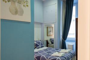 a blue bedroom with a bed with towels on it at Luxury Three Bedrooms flat in Roma Center in Rome