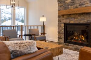 a living room with a fireplace and a table and chairs at Powder House Chalet by Fernie Central Reservations in Fernie