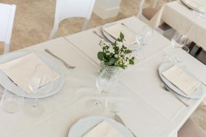 a white table with glasses and a vase of flowers at EUROPA Hotel in Vasto