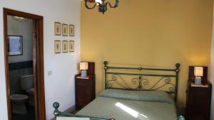 1 dormitorio con 1 cama y 2 mesitas de noche con lámparas en Agriturismo Borgo Santa Lucia, en Castiglion Fiorentino