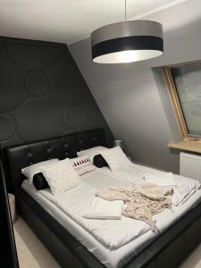 duże łóżko z czarnym zagłówkiem w pokoju w obiekcie Apartament przy Krupówkach w Zakopanem