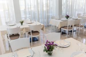 a dining room with white tables and white chairs at EUROPA Hotel in Vasto