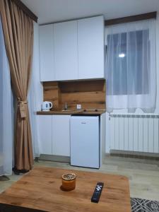 毛茛的住宿－View of the Durmitor，厨房配有白色冰箱和桌子