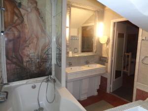 La salle de bains est pourvue d'une douche, d'une baignoire et d'un lavabo. dans l'établissement Hôtel les Degrés de Notre Dame, à Paris