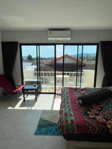 a bedroom with a bed and a balcony with a view at Petunya Phuket in Ban Huai Luk (1) +7 photos