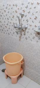 una maceta en un baño con papel pintado de pájaro en Tiger Guest House & Restaurant, en Sawāi Mādhopur
