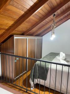um quarto com uma cama e uma parede de madeira em Gramado Centro 3 Hospede Loft 2 em Gramado