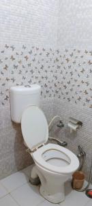 ein Badezimmer mit einem weißen WC mit Sternen an der Wand in der Unterkunft Tiger Guest House & Restaurant in Sawāi Mādhopur