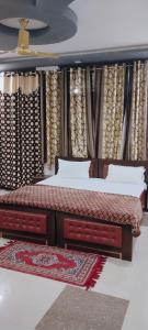 2 Betten in einem Zimmer mit Vorhängen in der Unterkunft Tiger Guest House & Restaurant in Sawāi Mādhopur