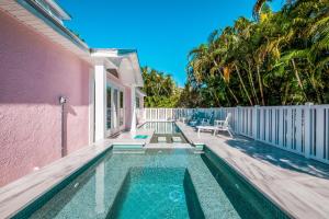 a swimming pool next to a pink house at Little Pink Houses in Anna Maria