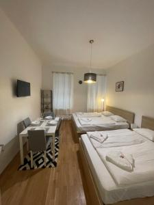 een kamer met drie bedden en een tafel erin bij Cozy 5-Person apartment in Vienna 2 in Wenen