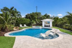 a swimming pool with two chairs and a gazebo at Lavender Lagoon in Anna Maria