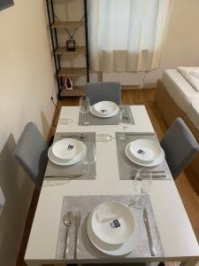een eettafel met borden en glazen erop bij Cozy 5-Person apartment in Vienna 2 in Wenen