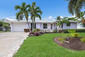 a white house with palm trees in the yard at Lavender Lagoon in Anna Maria