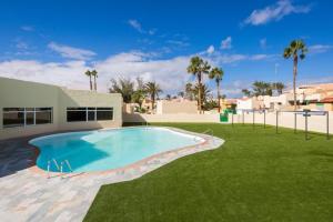 a large swimming pool in the yard of a house at 8202 - Wifi Costa Calma Bungalow in Costa Calma