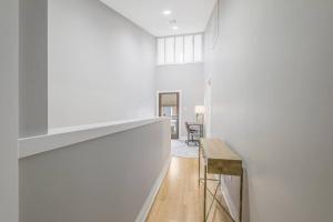 a hallway with white walls and a wooden table at Cozy 2 Bed Townhome near the Hospital in Lafayette