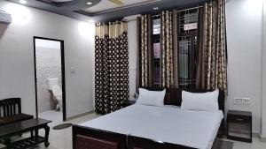 a bedroom with a large white bed and a mirror at Tiger Guest House & Restaurant in Sawāi Mādhopur