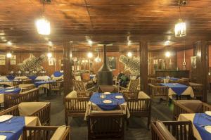 a restaurant with tables and chairs with blue tables at Nedous Hotel Gulmarg in Gulmarg