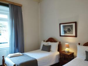 um quarto de hotel com duas camas e uma janela em Tapada Nacional de Mafra em Mafra