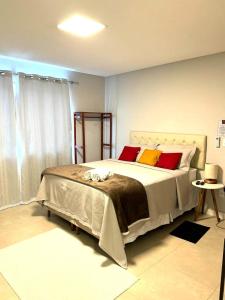 ein Schlafzimmer mit einem großen Bett mit roten und gelben Kissen in der Unterkunft Canto Alemão in Domingos Martins
