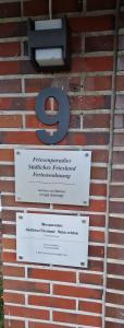 un panneau sur le côté d'un mur de briques dans l'établissement Moorparadies FRI-Südliches Friesland, à Bockhorn