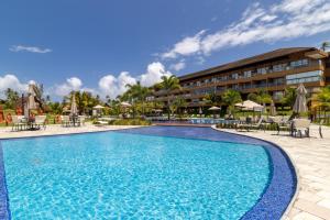 a pool at the resort with tables and chairs at Eco Resort Praia dos Carneiros Apt Luxo Beira Mar in Tamandaré