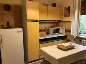 a kitchen with a table and a yellow refrigerator at Guest House Tisza Ház in Senta
