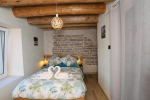 Un dormitorio con una cama con dos cisnes. en L'Hôtel Enfoncé, chambres d'hôtes, en Le Val-dʼAjol