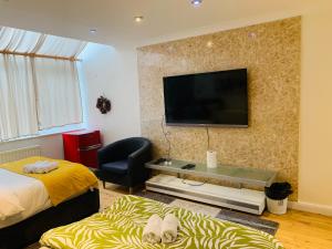 1 dormitorio con 2 camas y TV en la pared en Boogaard's Guest House, en Londres
