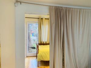1 dormitorio con cama y ventana con cortina en Boogaard's Guest House, en Londres