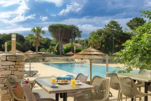 a patio with a table and chairs next to a pool at Camping Campo Di Liccia in Bonifacio