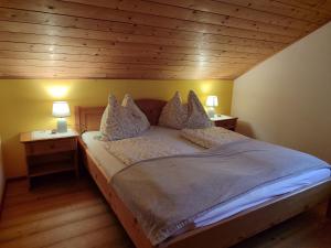 a bed in a room with two lamps on tables at Ferienwohnung Grubinger in Unterach am Attersee
