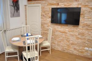 stół jadalny z telewizorem na murze w obiekcie Loft Casa Zeffirino w San Remo