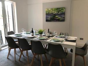 uma mesa de jantar com cadeiras e garrafas de vinho em Luxury 6 bedroom retreat in Stratford Upon Avon em Stratford-upon-Avon