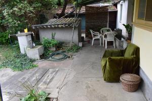 a patio with chairs and a table and a house at Guest House Tisza Ház in Senta