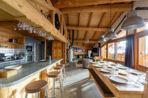 a kitchen with wooden ceilings and a long counter with bar stools at Chalet Lyskamm in Montvalezan