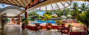 een resort met een zwembad en tafels en stoelen bij Resort Arcobaleno All Inclusive in Porto Seguro