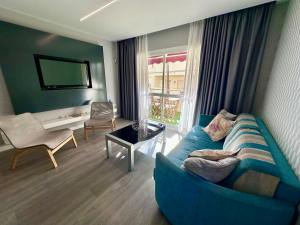 - un salon avec un canapé bleu et une table dans l'établissement Apartamento con vistas, Urb. Mijas golf., à Santa Fe de los Boliches