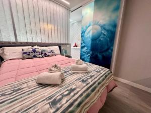 - une chambre avec un grand lit rose et des serviettes dans l'établissement Apartamento con vistas, Urb. Mijas golf., à Santa Fe de los Boliches